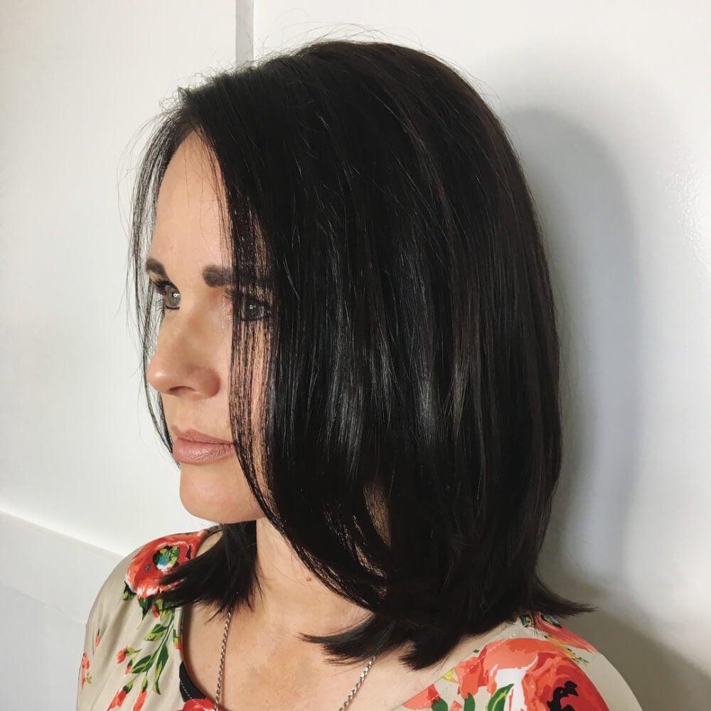 A sleek shoulder-length layered haircut with jet black hair for thin hair