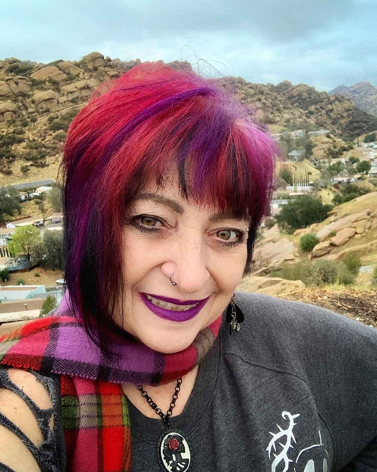 Woman over 60 with a very Edgy Pink Purple and Red haircut and Bangs